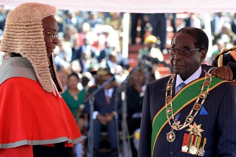 El presidente de Zimbabue, Robert Mugabe (dcha.), durante su juramento. | Afp
