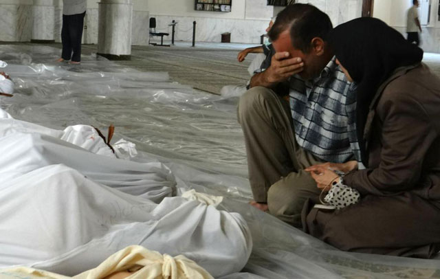 Un hombre y una mujer lloran la muerte de un allegado en Siria.| Afp