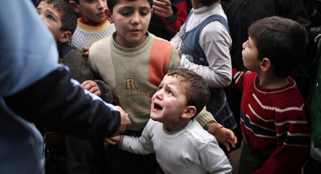 Un nio llora mientras espera para recibir ayuda humanitaria en la frontera con Turqua. | Reuters
