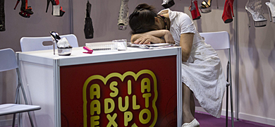 Una mujer se echa la siesta durante una feria en Hong Kong. | Efe