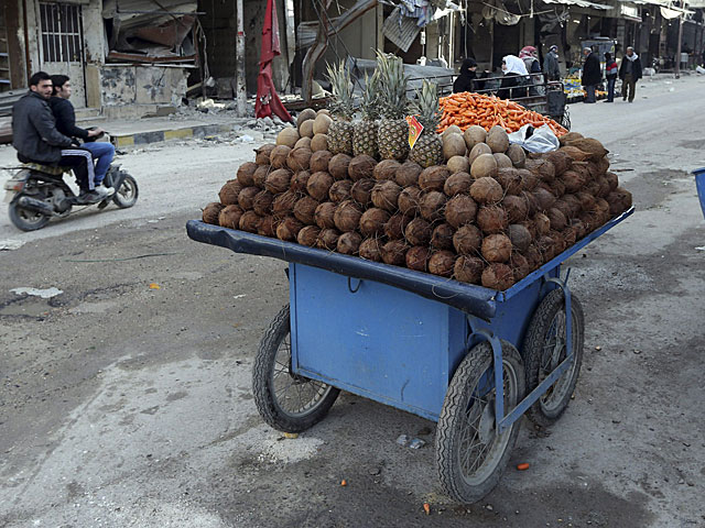 Un puesto ambulante de frutas, en una calle de un barrio de Damasco. | Reuters