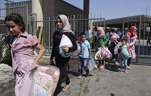 Refugiados sirios cruzando la frontera con Turquía. | Efe