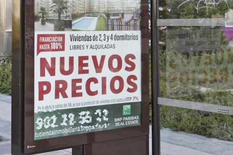 Cartel publicitario que anuncia 'Nuevos precios' en una promoción de viviendas. | S. Enríquez