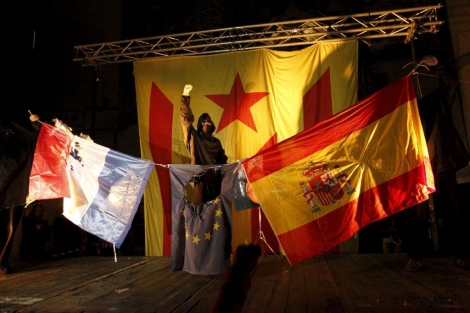 Uno de los encapuchados celebra la quema de los símbolos. | Jordi Soteras