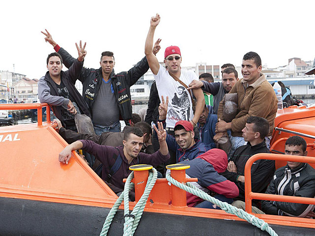Varios inmigrantes son conducidos al puerto de Motril. | Paquet / Efe