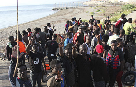 Algunos de los 91 inmigrantes de Ceuta tras alcanzar la playa. | Reduan / Efe