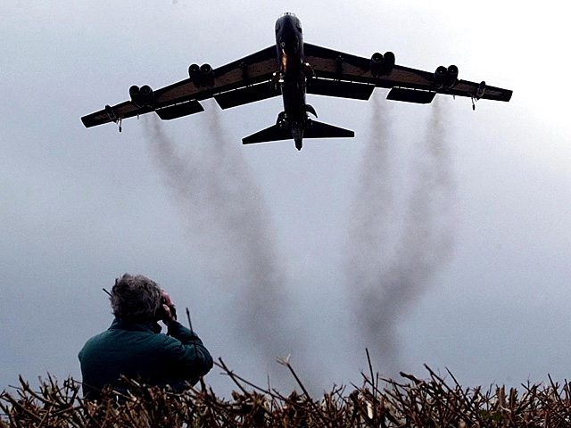 Un hombre mira un bombardero B 52 despegar de Fairford (Reino Unido) en 2003. | Afp