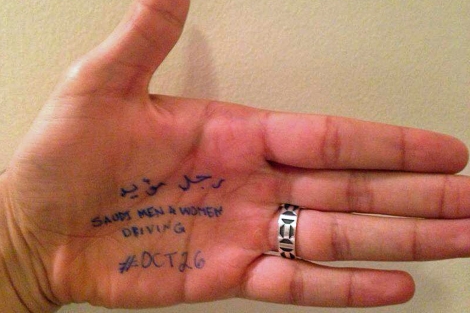 En la mano de esta mujer se lee 'Hombre y mujeres saudíes conduciendo. 26 de octubre'.
