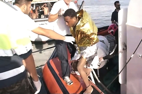 La guardia costera ayuda a un inmigrante a desembarcar. | Afp