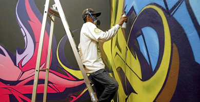 Un grafitero pintando una pared. | D. Umbert