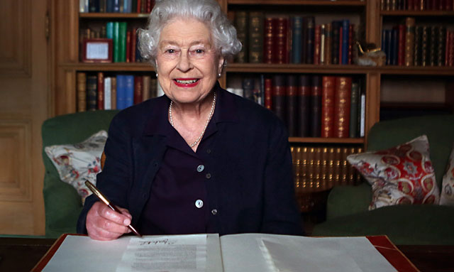Isabel II, firmando un mensaje para los atletas de la Commonwealth. | Reuters/Pool
