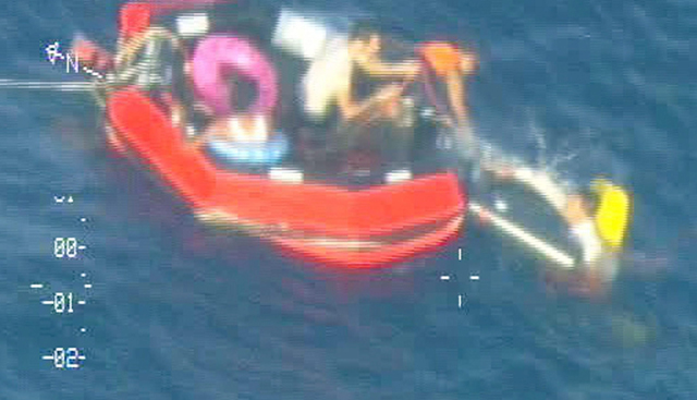 Imagen del rescate de uno de los inmigrantes que viajaba en la embarcacin. | Efe