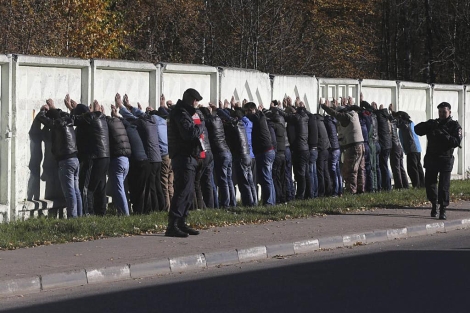 Agentes de polica vigilan a varios detenidos en Mosc. | Efe