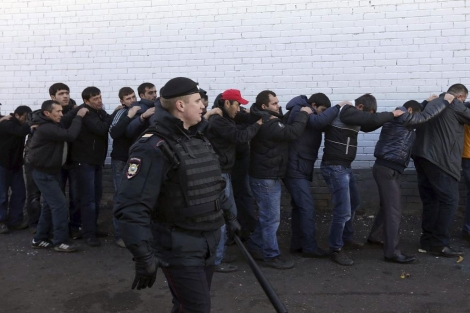 Un agente de policía vigila a varios detenidos en Moscú. | Efe