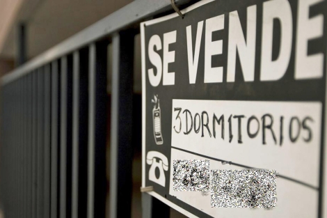 Cartel de 'Se vende' colgado en el balcón de una vivienda. | Roberto Cárdenas