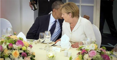 Obama habla al odo de Merkel, en Berln en junio. | Efe