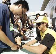 Rossi firma autgrafos en el circuito de Shanghai. (Foto: AP)