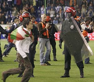 Policas vascos protegen a los jugadores y las instalaciones de Mendizorroza, tras consumarse el descenso del Alavs. (Foto: EFE)