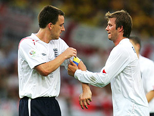 Beckham (d) le coloca a Terry el brazalete de capitán durante un partido de Inglaterra. (Foto: REUTERS)
