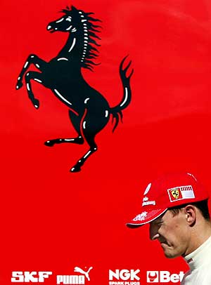 Michael Schumacher pasa por delante del logo de Ferrari. (Foto: REUTERS)