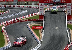 Loeb (i) y Gronholm (d) conducen sus coches durante la ltima especial, disputada dentro del estadio del Algarve, en Faro. (Foto: AP)