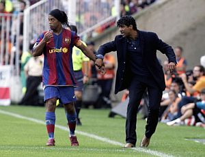 Rijkaard da instrucciones a Ronaldinho en El Sardinero. (Foto: AFP)