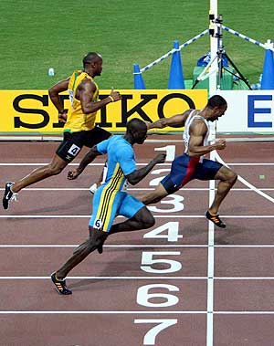 Asafa Powell, al fondo, cruza la lnea de meta en tercera posicin en la final de los 100 m. de los Mundiales de Osaka. (Foto: EFE)