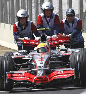 Lewis Hamilton, empujado por los auxiliares del circuito de Interlagos tras la clasificacin. (Foto: AFP)