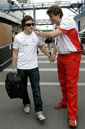 Alonso recibe el apoyo de un mecnico de Ferrari al abandonar el circuito de Interlagos. (Foto: AP)