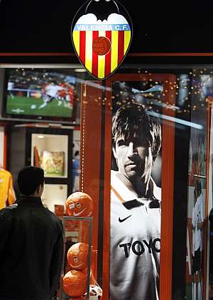 Un aficionado contempla la imagen de David Albelda que se expone aún en la tienda oficial del Valencia. (Foto: EFE)