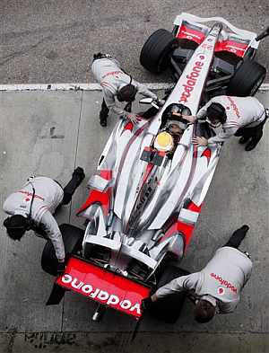 Los mecnicos de McLaren empujan el coche de Hamilton. (Foto: AP)