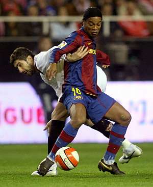 Ronaldinho protege la pelota ante Dragutinovic. (Foto: AFP)