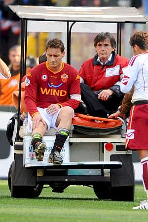 Totti sali del campo en camilla y con mala cara. (Foto: EFE)