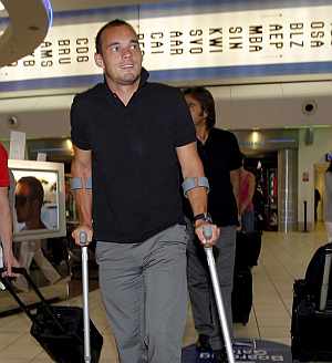 Sneijder, apoyado en sus muletas, en el aeropuerto de Londres. (Foto: EFE)