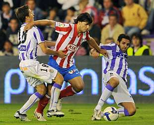 Agero intenta regatear a dos jugadores del Valladolid. (Foto: EFE)