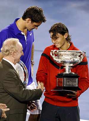 Rafa Nadal recibe el trofeo de campeón de manos de Rod Laver, ante Roger Federer. (EFE)