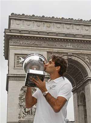 Federer besa la Copa de los Mosqueteros en los Campos Elseos. (Foto: EFE)