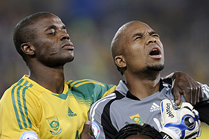 Dos jugadores Sudafricanos, durante el himno nacional. (AP Photo).