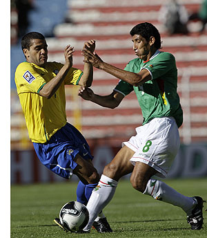 Alves y Olivares, autor del primer gol boliviano, pelean por un baln. (Foto: AP)