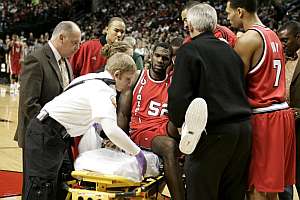 Greg Oden, retirado en camilla. (Foto: AP)