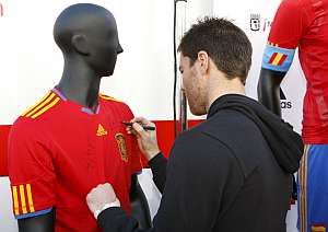 Xabi Alonso firma una camiseta de Espaa despus de donar sangre en Madrid. | EFE