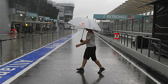 Un mecnico de McLaren bajo la lluvia. (Foto: AP)