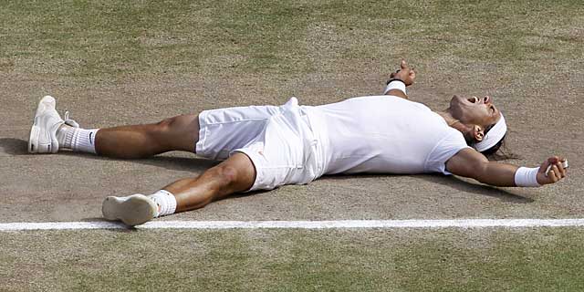 Nadal, tumbado sobre la hierba de Wimbledon tras su segunda corona. (AFP)