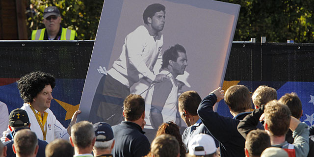 Un miembro del equipo europeo porta una imagen de Olazbal y Ballesteros. | Reuters