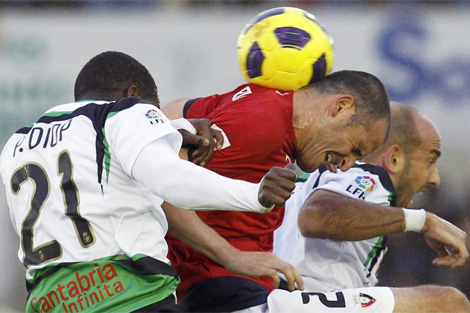 Fernando Soriano (c) disputa un baln por alto durante un partido contra el Racing. Foto: Efe