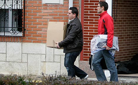 Dos policas cargan con pruebas tras registrar la vivienda de Marta Domnguez. (Foto: Reuters)