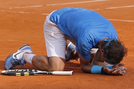 Rafa Nadal, arrodillado en la arcilla deRoland Garros, celebra su triunfo ante Federer. (AFP)