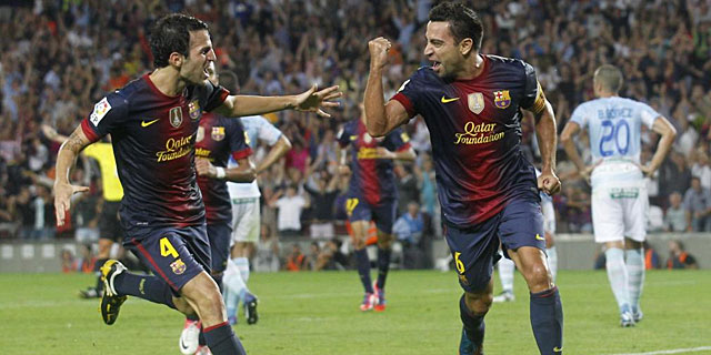 Xavi y Cesc celebran el primer tanto del Barcelona. | Reuters