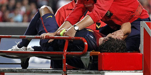 Carles Puyol, en el momento de ser retirado en camilla. | Reuters