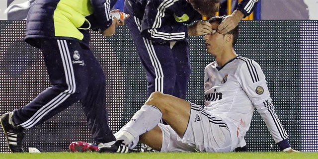 Cristiano Ronaldo, atendido en la banda tras el codazo de David Navarro. (EFE)